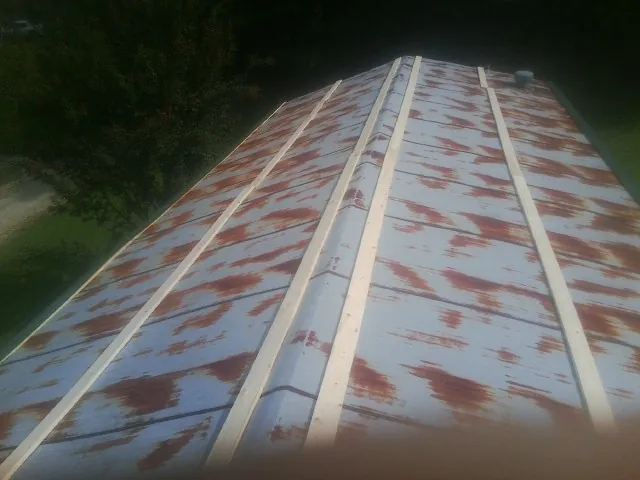 Rusted metal roof panels with new wood purlins before replacement — Storm Damage Roof Repair in Eldridge by Roofing Brothers
