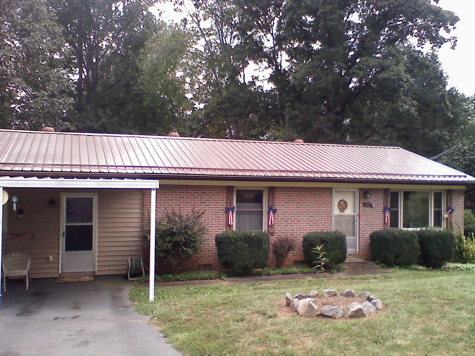 Bronze metal roof and carport on a brick ranch home — Roof Repair work by our crew in Eldridge
